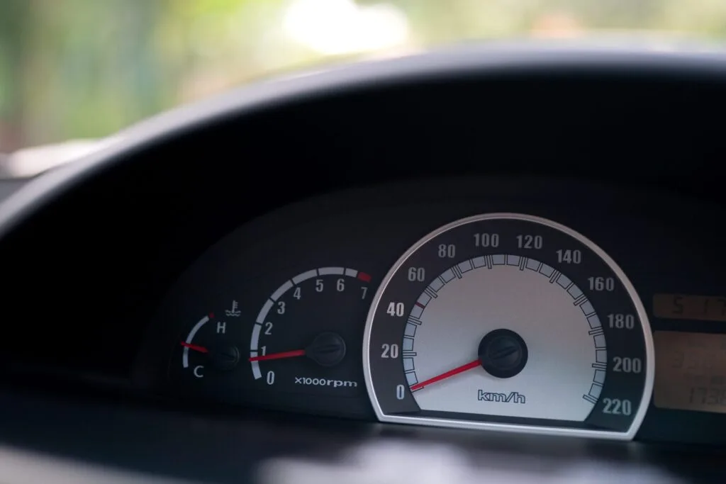 18 Questions Essential to know the Answers 4 Detailed close-up of a car's speedometer, showcasing the needle pointing to the current speed in a sleek dashboard design.