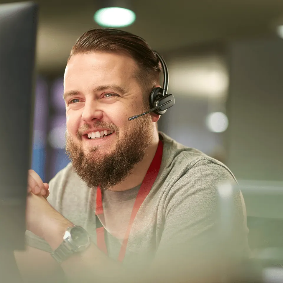 Customer Service Training 17 Smiling customer service representative wearing a headset at his workstation